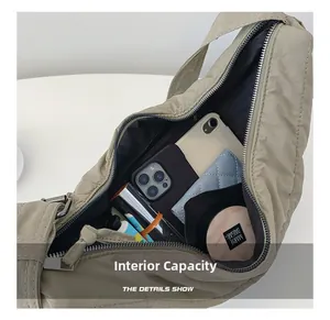 Macro view of khaki nylon shoulder bag interior capacity with zipper and daily items