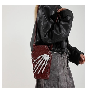Macro shot of deep red coffin bag featuring skull relief and white skeletal hand details
