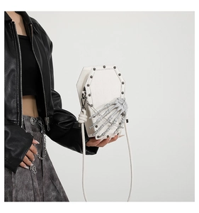 Detail of white PU leather coffin shoulder bag with skull bone and silver studs