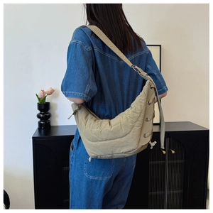 Detail of khaki nylon crescent bag with side lace-up eyelets and quilted texture