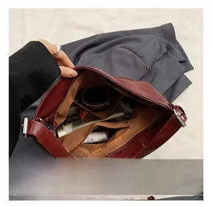 Macro shot of dark red PU leather handbag interior showing spacious compartments and zipper pocket