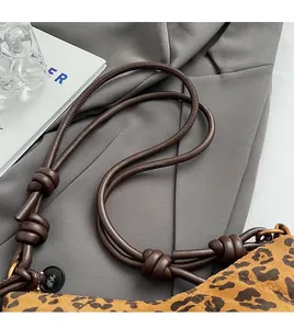 Détail d'un sac bandoulière léopard avec bandoulière en cuir à nœuds décoratifs