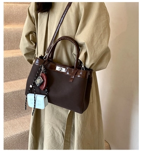 Detail view of coffee tote bag with silver metal lock and decorative mini charms