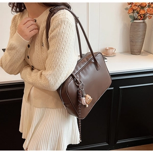 Détail d'un sac à bandoulière en cuir PU marron foncé avec un bijou de sac de sport