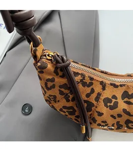 Détail du sac en daim léopard montrant la fermeture éclair dorée et le logo mode