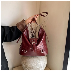 Detail of burgundy PU leather tote bag with pleated texture and vintage metal hardware