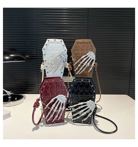 Detail view of coffin-shaped PU leather crossbody bags with skull embossing and rivet accents