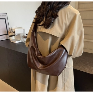 Deep brown large capacity PU leather hobo bag worn by a model in a minimalist cafe