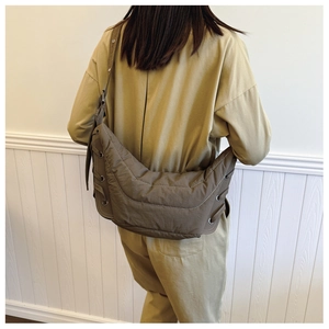 Detailed back view of a quilted nylon crescent crossbody bag in olive green with side ties