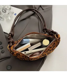 Détail intérieur du sac à bandoulière en daim léopard montrant l'espace de rangement