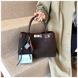 Detail of vintage brown canvas handbag with shiny leather trim and modular accessories