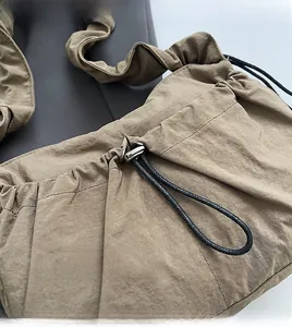 Dettaglio della borsa a tracolla in nylon kaki con coulisse regolabile e chiusura metallica