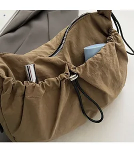 Dettaglio borsa a tracolla in nylon con tasca frontale per piccoli cosmetici