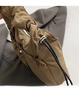 Dettaglio della borsa a tracolla in nylon alla moda con coulisse e fibbia in metallo