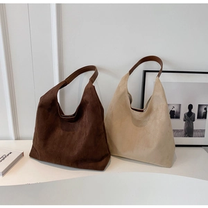 Detail of minimalist large suede hobo bags in dark brown and beige with leather shoulder straps