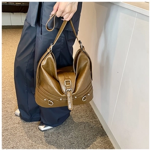 Close-up of olive green PU leather tote bag featuring silver buckles and D-ring detail