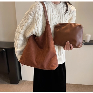 Detail of hobo tote bag and matching pouch showing contrast of suede and leather textures