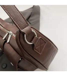 Detailansicht des silbernen Metallrings und der verstärkten Nähte an der braunen PU-Tasche