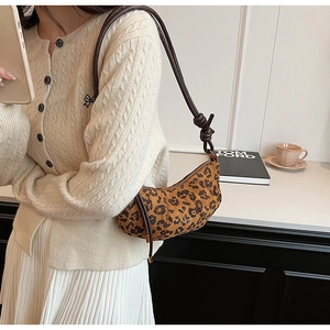 Détail d'un sac baguette imprimé léopard avec bandoulière en cuir marron nouée