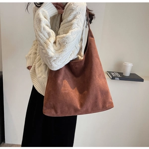 Red-brown large suede tote bag styled with white sweater for a cozy autumn look