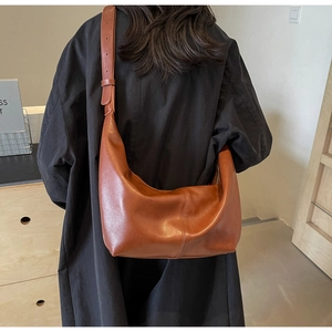Close-up of brown PU hobo bag featuring wide adjustable strap and vertical stitching detail