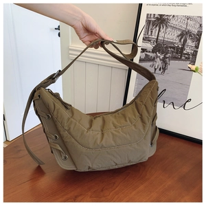 Stylish olive green quilted nylon hobo bag featuring decorative metal eyelet straps