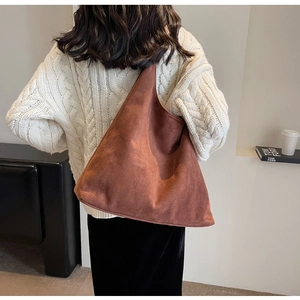 Detailed back view of a brown suede tote bag styled with a white knit sweater
