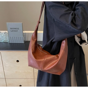 Detailed close-up showing the smooth brown leather texture and stitching of hobo bag