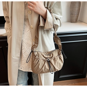 Dettaglio della borsa a tracolla in nylon kaki con elegante trama plissettata e coulisse