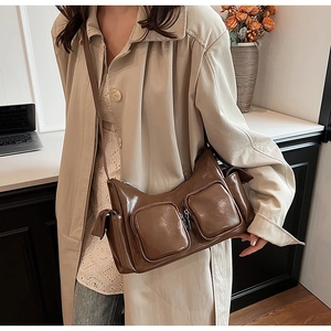 Close-up of brown glossy PU leather shoulder bag with functional dual zipper pockets