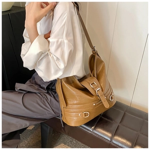 Close-up of stylish brown PU leather hobo bag with silver buckle and pleated detail