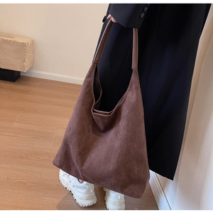 Detail view of large dark brown suede hobo tote bag with smooth leather shoulder strap