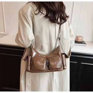 Detailed view of brown PU leather crossbody bag with multiple zip pockets and silver hardware