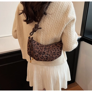 Détail d'un sac bandoulière en daim à motif léopard avec un nœud sur la bandoulière