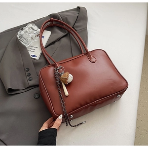 Sac à main chic en cuir PU marron rouge avec pendentif baseball dans un décor urbain