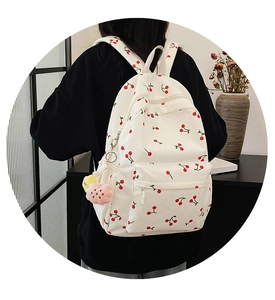 Détails du sac à dos en velours côtelé blanc avec imprimé cerise et breloque fleurie