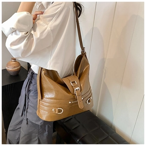 Close-up of vintage brown PU leather tote bag with silver metal buckles and D-ring detail