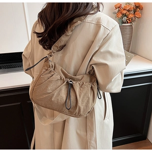 Dettaglio della borsa a tracolla in nylon marrone con coulisse e design a pieghe