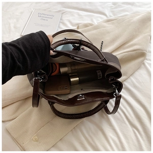 Top view of spacious interior of brown PU shoulder bag with daily essentials inside