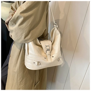Close-up of beige PU leather hobo bag with pleated texture and silver buckle details