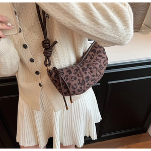 Détail du sac croissant matelassé à imprimé léopard avec bandoulière nouée réglable