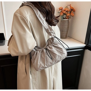 Dettaglio della borsa a tracolla in nylon beige con pieghe a nuvola e chiusura a coulisse