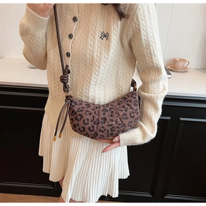 Détail du sac croissant à imprimé léopard avec cordon de serrage et bandoulière en cuir