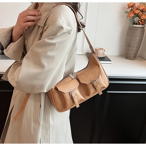 Detailaufnahme der karamellfarbenen PU-Schultertasche mit Schnallentaschen und Metallreißverschluss
