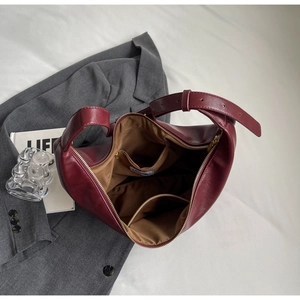 Detail view of burgundy leather hobo bag interior with zip pocket and textile lining