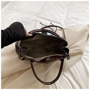 Top-down view of a dark brown PU leather tote bag with light gray fabric lining