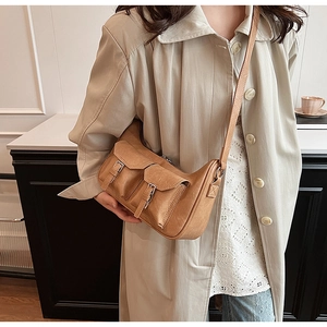 Detailansicht der kamelbraunen PU-Leder Umhängetasche mit Vintage-Schnallen am Trenchcoat