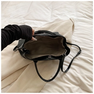 Top view of spacious interior of black PU tote bag with grey lining and metallic zipper