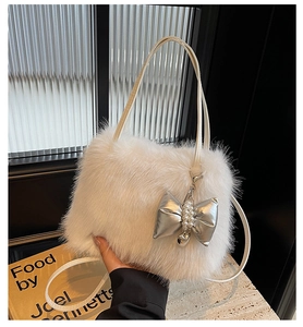 Close-up of white plush crossbody bag featuring silver bow and pearl pendant details