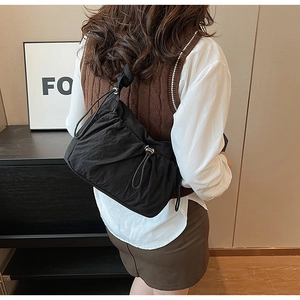 Dettaglio borsa a spalla in nylon arricciato nero che mostra texture e vestibilità